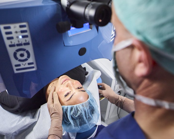 Augenarzt führt eine Augenlaserbehandlung bei einer Patientin durch