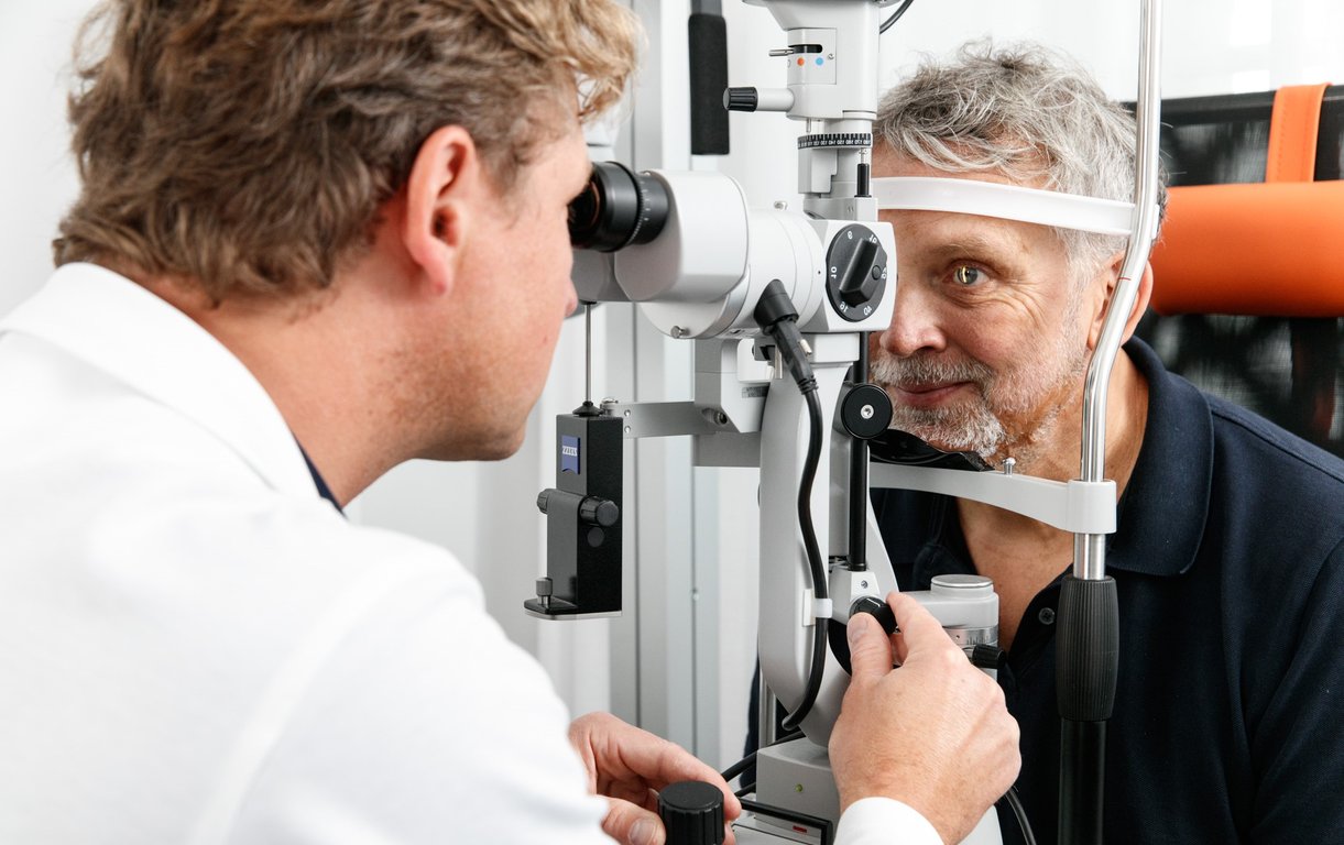 Ein Augenarzt führt an einer Spaltlampe eine detaillierte Untersuchung des Augenhintergrunds bei einem Patienten durch.