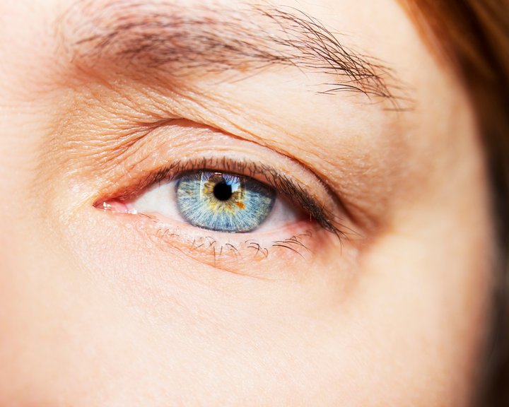 Detailreiche Nahaufnahme eines hellblauen menschlichen Auges mit feinen Strukturen in der Iris und umgebender Hautpartie.