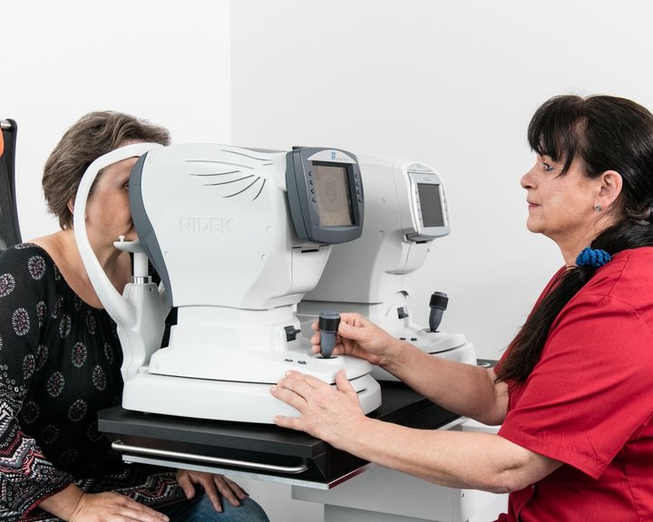 Eine medizinische Fachkraft führt bei einer Patientin eine automatisierte Augenvermessung mit einem NIDEK-Diagnosegerät durch.